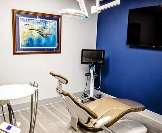 A treatment room at the practice, with a marlin painting on the wall and a chairside monitor.